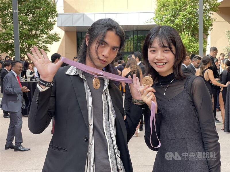 台灣設計師李政瀚(左)、于薇(右)3日獲得第64屆葛萊美獎最佳唱片包裝設計獎。兩人在頒獎會場秀出入圍獎章。中央社記者林宏翰拉斯維加斯攝 111年4月4日