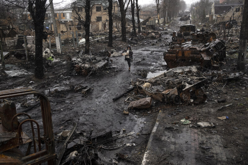 烏克蘭布查鎮2月26日遭俄軍占領，直到3月31日砲擊停止，烏克蘭才奪回掌控，隨即發現平民遭受到大規模惡行。圖為3日布查一名婦女行經被摧毀的俄羅斯坦克。（美聯社）