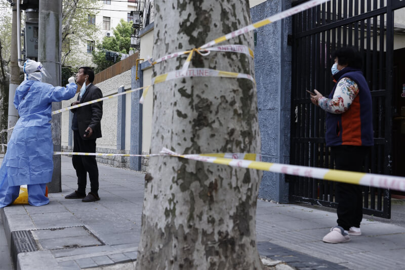 上海再度傳出感染COVID-19致死的消息，據通報，18日新增7名死亡病例，均為60歲以上的年長者。圖為醫護人員5日在上海市街頭為市民進行採檢。（中新社）