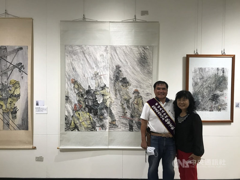 由周大觀文教基金會舉辦的「畫出光點.照亮世界」聯展,展出台電員工李升茂以水墨畫記錄搶修工程的艱辛歷程,8日在中正紀念堂揭幕。圖為李升茂(左)偕妻子在畫作前合影。中央社記者邱祖胤攝 111年4月8日