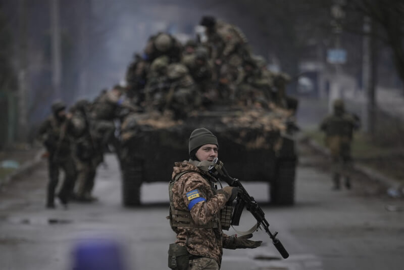圖為烏克蘭軍人4月在基輔郊外爬上戰車，士兵回頭望去。（美聯社）