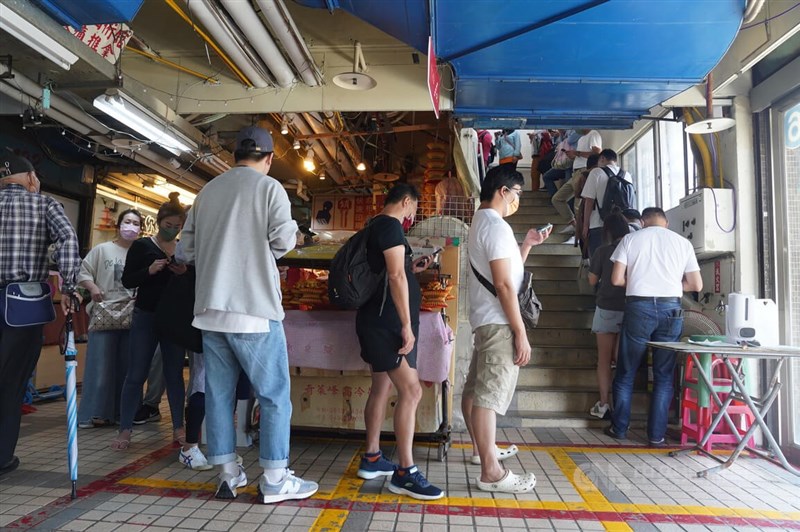 國內COVID-19疫情延燒,本土個案連日破百,台北市北投市場知名滷肉飯店9日仍出現長長排隊人龍,民眾戴著口罩從2樓排到1樓。中央社記者徐肇昌攝 111年4月9日