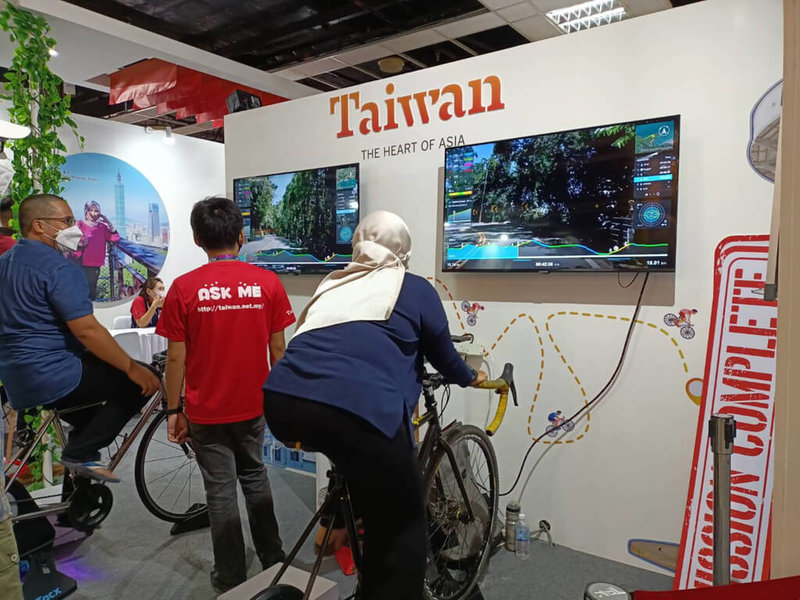 馬來西亞開放國境後，吉隆坡首場國際旅展本週末登場，台灣館以實景騎乘方式吸引民眾體驗台灣自行車旅遊。（觀光局駐吉隆坡辦事處提供）中央社  111年4月10日