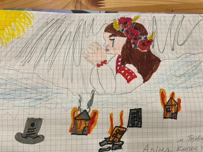 有些兒童描繪身著烏克蘭傳統服飾的婦女正流淚祈禱,一旁全部都是被砲彈轟炸起火或倒塌損毀的房屋。 (王芮緹提供) 中央社記者黃雅詩台北傳真 111年4月11日