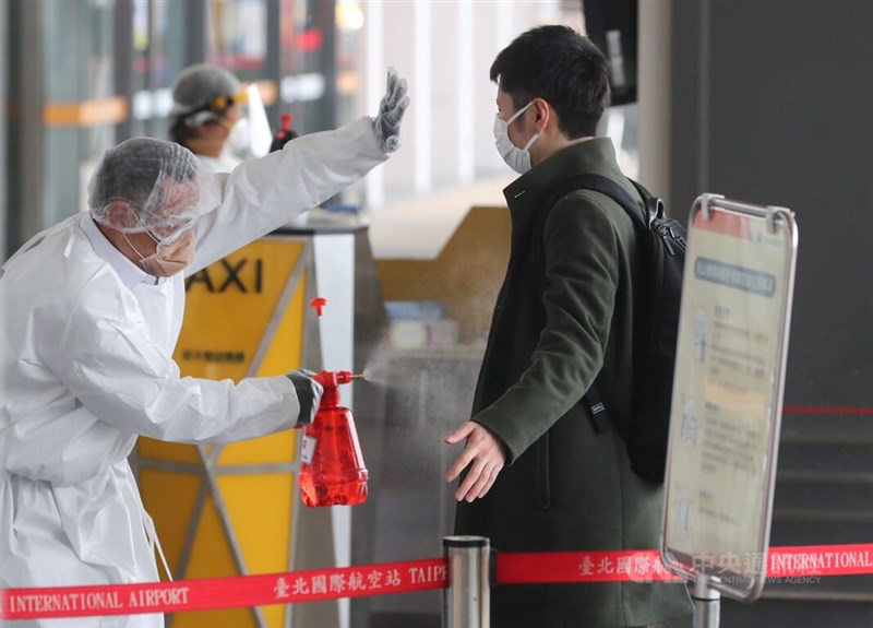 圖為台北松山機場國際線入境旅客，搭乘防疫計程車前全身消毒。（中央社檔案照片）