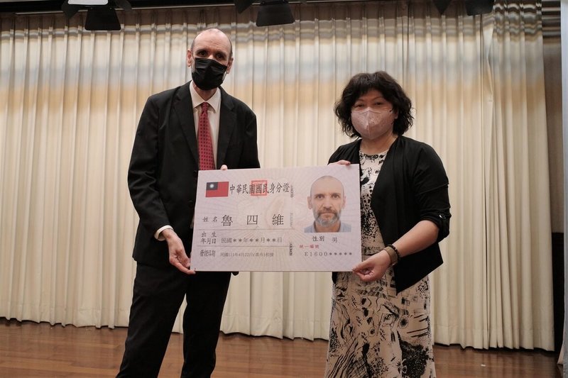 文藻外語大學西班牙籍教授魯四維(左)20多年前來台任教,在教育、研究領域都有卓越貢獻,以外國高級專業人才身分獲淮取得中華民國國籍,22日從前鎮戶政事務所主任賴立齡(右)手中領到新身分證。(高雄市政府提供)中央社記者曾以寧傳真 111年4月23日