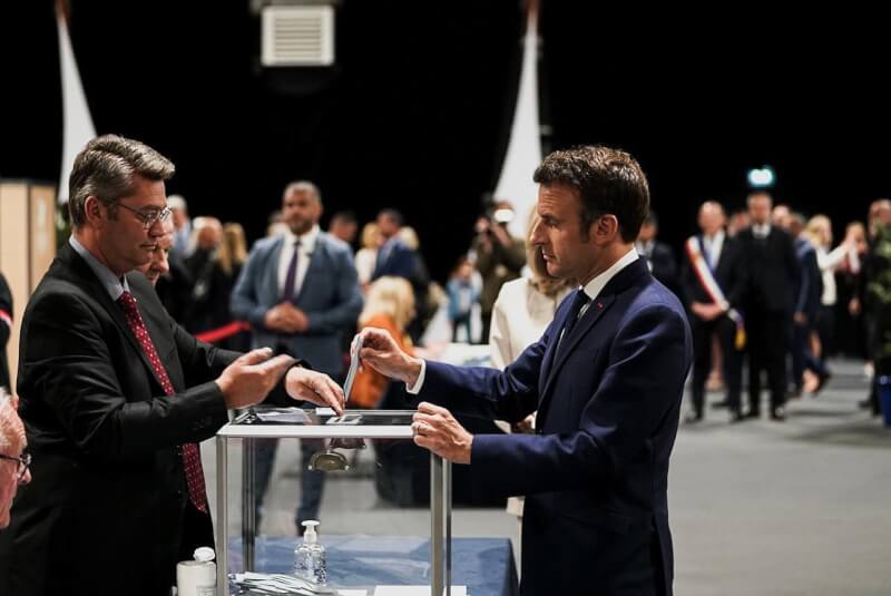 法國總統大選底定，現任總統馬克宏（右）連任成功。圖為馬克宏24日前往投票。（圖取自facebook.com/EmmanuelMacron）