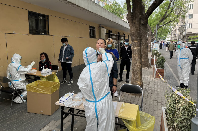 北京市宣布，從26日起至30日，也要對其餘15個行政區中的10個區及經濟開發區，展開3輪全員核酸檢測。圖為25日北京朝陽區民眾接受核酸檢測。（中新社）