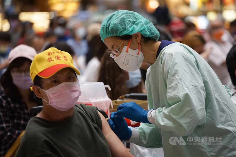 圖為醫護人員下午在台北車站接種站依序為民眾施打疫苗。中央社記者裴禛攝　111年4月27日