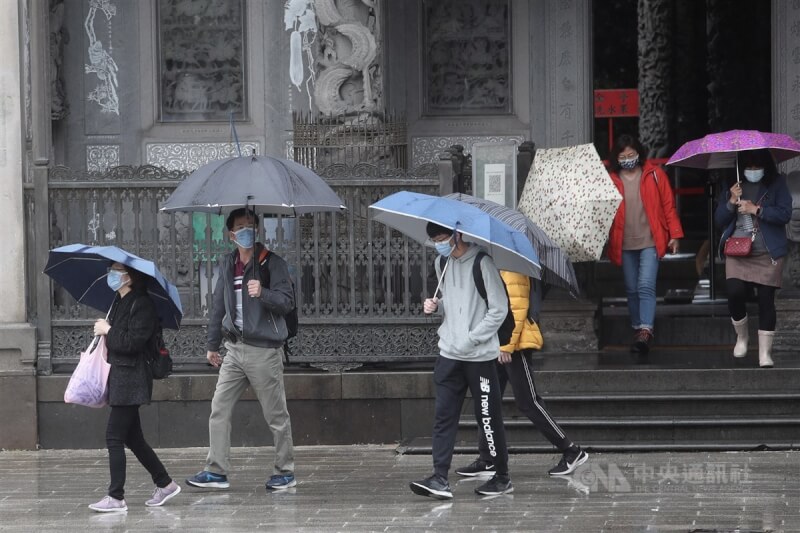 氣象局表示，4月30日起逐漸降溫，5月2日清晨北台灣最冷低溫約18、19度。圖為民眾撐傘至新北市三峽祖師廟。（中央社檔案照片）