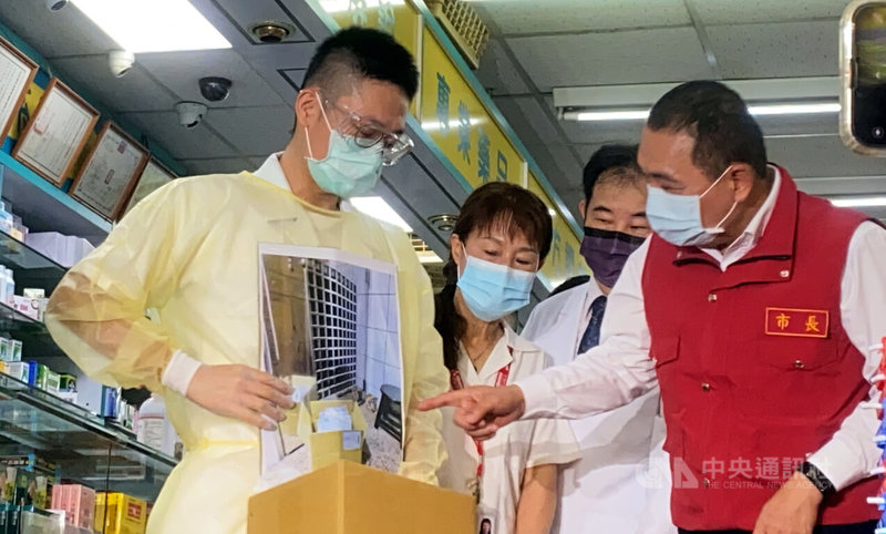 新北市長侯友宜（右）28日前往板橋區的一家社區藥局，實地了解藥師為居家照護確診者送藥流程。中央社記者黃旭昇新北市攝 111年4月28日