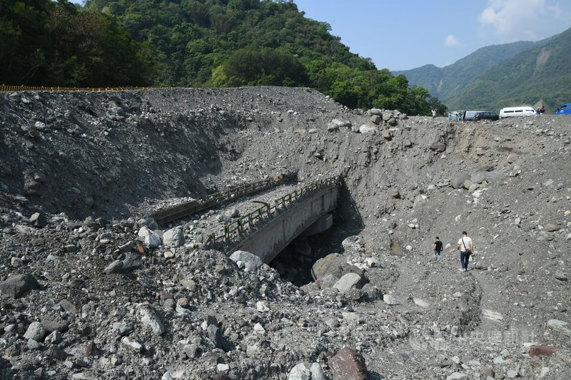 明霸克露橋於110年8月遭埋,經過半年的搶修與建造,終於在目前的涵管便道上游搭出短期鋼便橋,提升抗洪能力。工程人員往下挖掘土石,明霸克露橋意外「出土」,舊橋跟鋼便橋的高低落差達18公尺。中央社記者趙世勳攝 111年4月29日