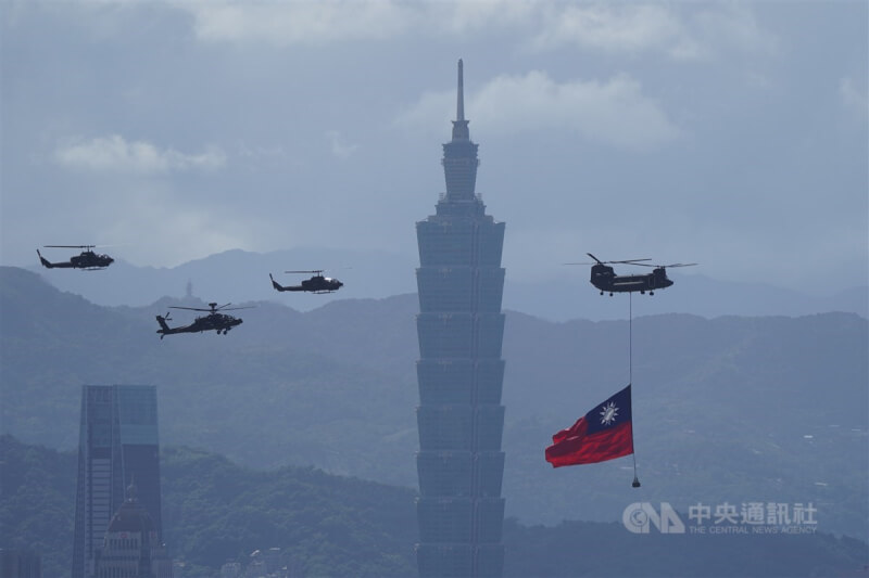 標普全球29日調升台灣主權評等至AA+，這是台灣相隔近21年再次升到這個等級。圖為去年國慶當天，陸軍CH-47運輸直升機吊掛巨幅國旗行經台北101大樓。（中央社檔案照片）