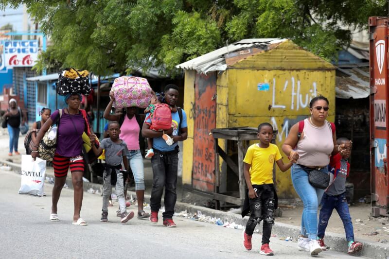 海地首都太子港敵對幫派為搶地盤而爆發槍戰已超過一週，警方無力處置。圖為海地民眾紛紛逃離家園。（路透社）