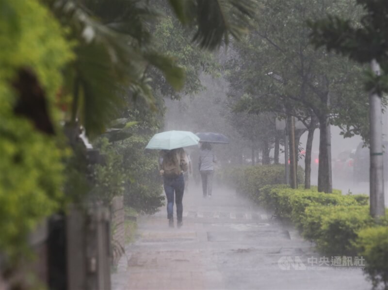 氣象專家吳德榮說，今年梅雨季的第1波「滯留鋒」13日報到。圖為民眾雨中撐傘。（中央社檔案照片）