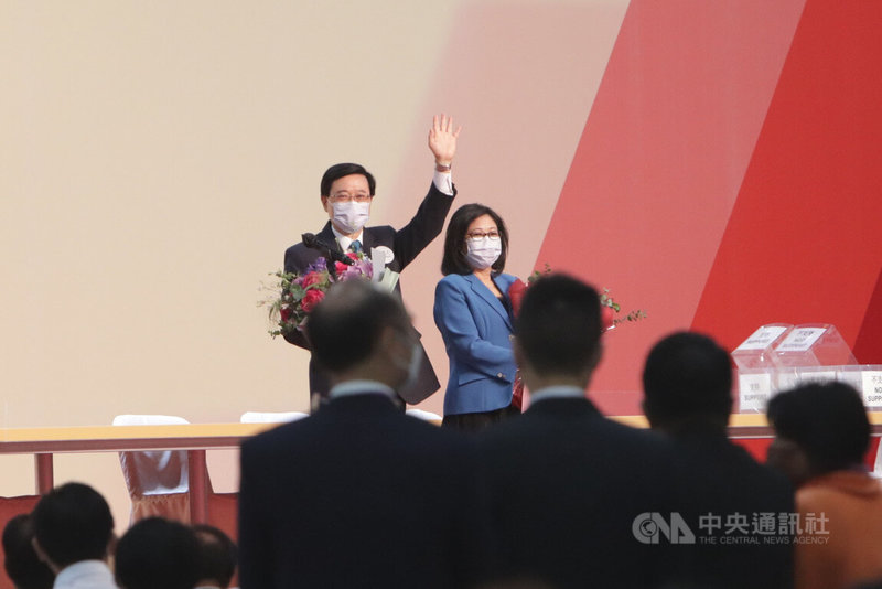 第6屆香港行政長官（特首）選舉8日舉行，前政務司司長李家超一如預期當選，圖為李家超（左）當選後與妻子在台上向嘉賓揮手。中央社記者張謙香港攝  111年5月8日
