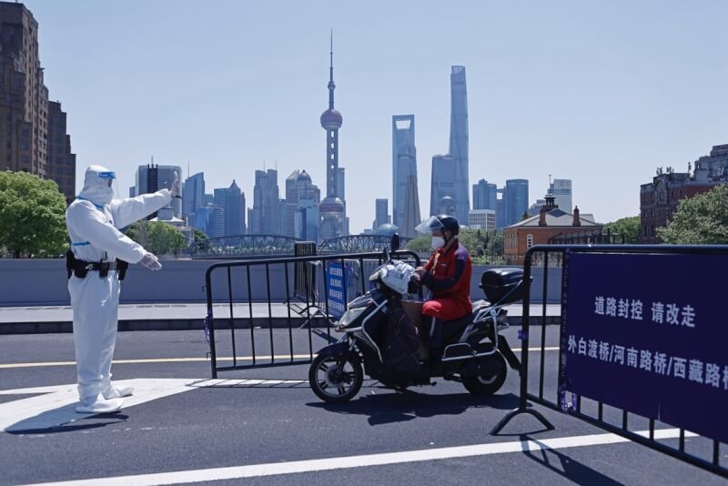 中國堅持清零消滅疫情，即使重創經濟也在所不惜。圖為5月上海警方攔檢外送員車輛。（中新社）