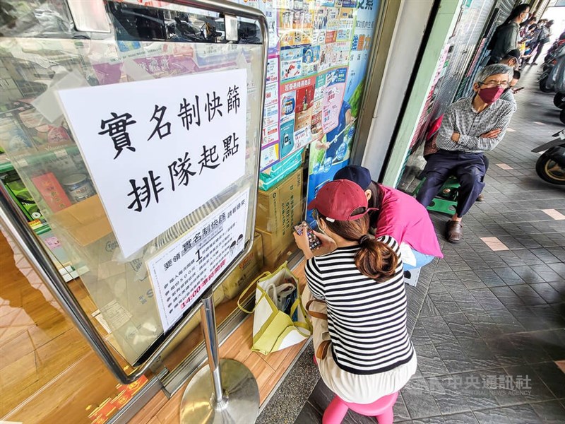 本土疫情升溫，民眾對快篩試劑的需求增加，台北市文山區一間藥局外7日午後有民眾直接帶板凳前來排隊購買實名制快篩試劑。（中央社檔案照片）