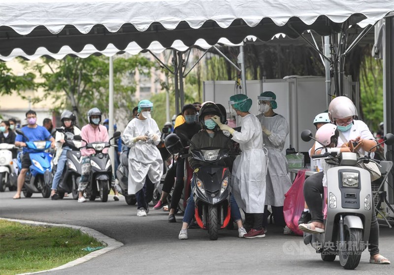 國內疫情持續延燒，高雄市同盟公園車來速篩檢站4日有大批機車騎士騎車前往採檢。（中央社檔案照片）