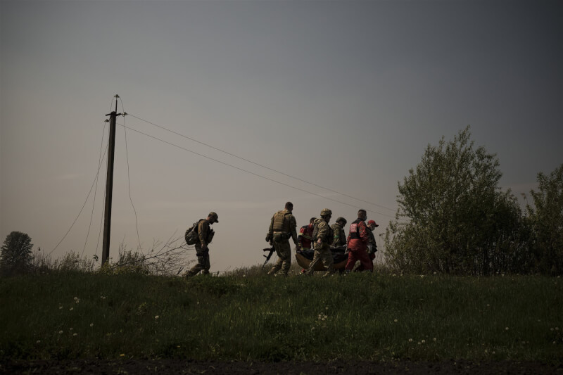 烏克蘭東北部哈爾科夫州州長西涅古波夫說，救援人員10日在伊久姆鎮一座被毀建築物的廢墟下發現44具平民屍體。圖為烏軍在哈爾科夫附近收復的城鎮搬運疑似俄軍屍體。（美聯社）