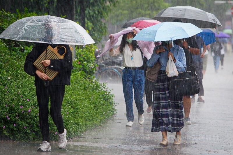 中央氣象局預報，13日全台及外島降雨機率高。圖為新北市12日午後下起大雨，忘了攜帶雨具的民眾被淋的一身溼。（中央社檔案照片）