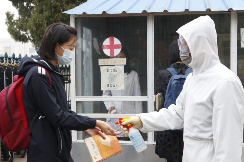 北韓官媒12日證實，國內至少有1人因感染COVID-19不治。圖為去年11月北韓學生進校園前先消毒手部。（美聯社）