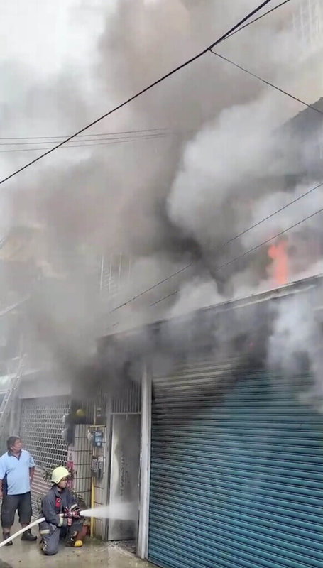 苗栗市一棟透天厝13日發生火警,起火住宅一樓不斷竄出火舌、濃煙密布,受困屋內的母子躲在2樓後方房間避難,在消防隊撲滅火勢後順利獲救。(民眾提供)中央社記者管瑞平傳真 111年5月13日