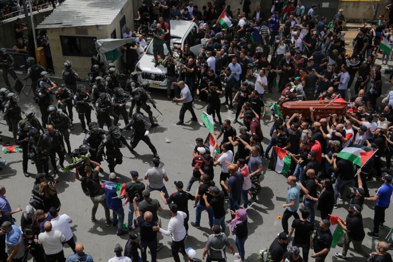 半島電視台記者阿克萊葬禮13日爆發警民衝突，以色列警察衝向巴勒斯坦出殯隊伍，現場一片混亂。（美聯社）
