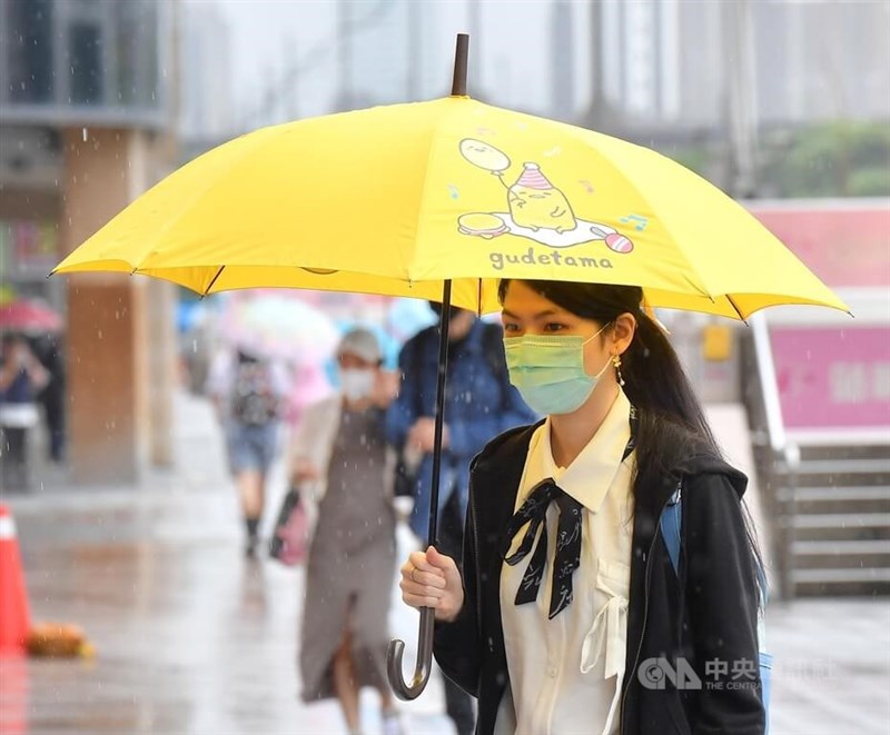 中央氣象局表示,15日晚上到16日水氣增多,各地降雨狀況轉趨明顯,西半部要留意有局部大雨發生機率。圖為台北車站前民眾撐傘走在街頭。中央社記者王飛華攝 111年5月14日