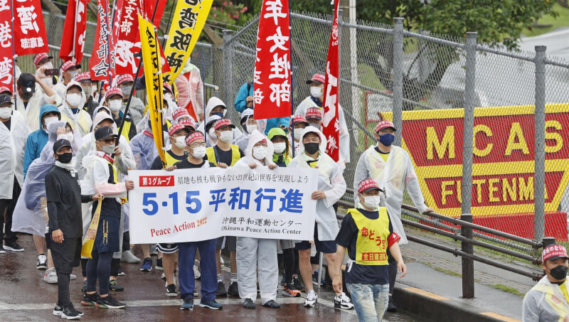 圖為14日沖繩民眾發起「平和行進」遊行經過美軍普天間基地外面，他們訴求打造沒有美軍基地的沖繩。（共同社）