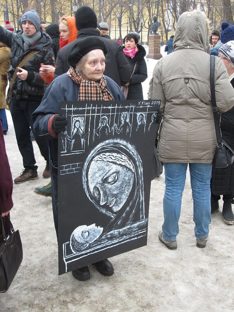 奧西波娃2002年首次走上街頭，此後時常舉著自製的標語牌抗議，被人稱為「聖彼得堡的良心」。圖為2019年她上街抗議的畫面。（圖取自維基共享資源；作者Alexei Kouprianov，CC BY 4.0）