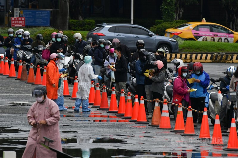 一旁機車道也有許多機車騎士排隊等候,醫護人員在一旁協助。中央社記者趙世勳攝 111年5月17日