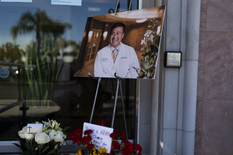 52歲台裔醫生鄭達志15日為了阻止槍手行凶而身亡。圖為16日鄭達志的照片被放在他的辦公室外，民眾獻上卡片與鮮花悼念。（美聯社）