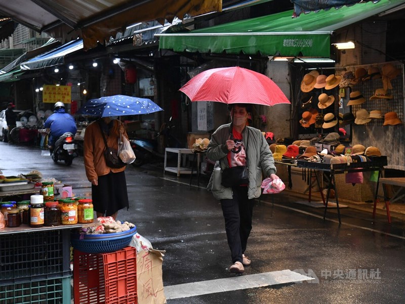 圖為16日上午台北市太平市場，民眾撐傘外出採買。（中央社檔案照片）