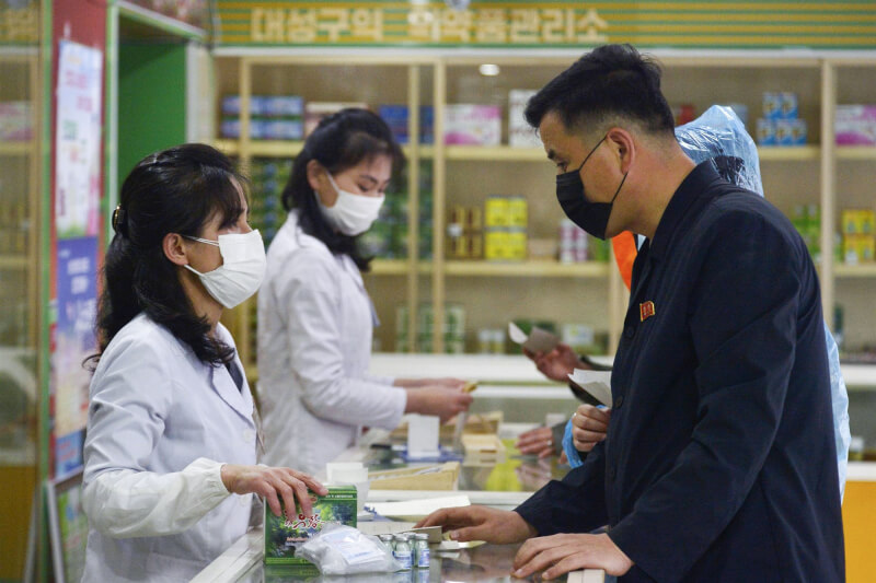 北韓中央通信社19日報導，北韓通報新增26萬2270人出現發燒症狀和1人死亡。圖為平壤民眾赴藥局買藥。（共同社）