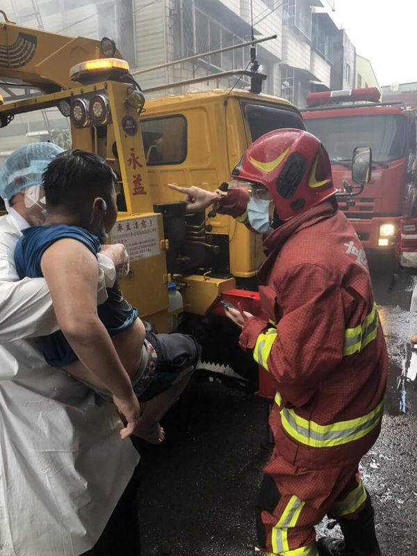 高雄大寮開封街一棟透天民宅20日上午發生火警，11歲男童受困3樓陽台，消防局布水線並架梯將他救出，所幸僅輕微嗆傷。（讀者提供）中央社記者洪學廣傳真  111年5月20日