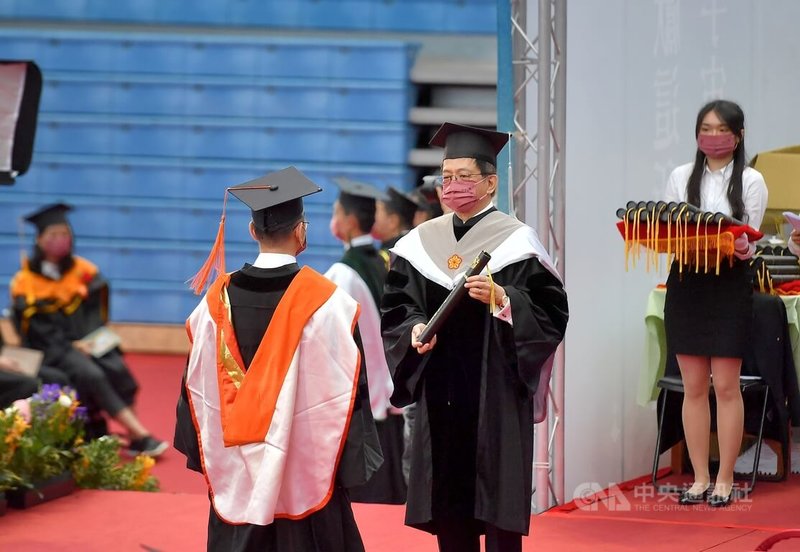國立台灣大學21日上午在綜合體育館舉行110學年度畢業典禮,校長管中閔(中)頒發畢業證書給畢業生,獻上祝福。中央社記者王飛華攝 111年5月21日