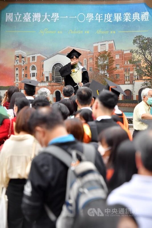 國立台灣大學21日上午舉行110學年度畢業典禮,典禮後畢業生在校園布置的看板前拍照留念。中央社記者王飛華攝 111年5月21日