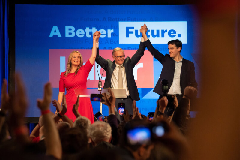 澳洲勞工黨在21日大選贏得勝利，即將接任總理的黨魁艾班尼斯（中）勝選後和伴侶赫頓（左）及兒子奈森一同舉手歡慶。（法新社）