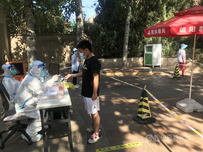 為了及早防止COVID-19疫情擴散，中國正推動核酸檢測常態化，在省會和1000萬以上人口城市設置步行15分鐘的「核酸採樣圈」，讓核酸採樣成為居民生活的日常。圖為北京朝陽區居民在做核酸檢測。中央社記者張淑伶北京攝  111年5月25日