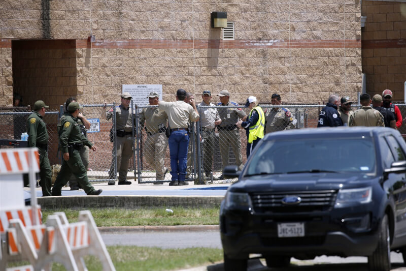 美國德州有關當局28日還原3天前小學槍擊案發過程，表示約20名員警在走廊等了近一個小時才攻堅擊斃槍手。圖為執法人員第一時間聚集在洛伯小學外。（美聯社）