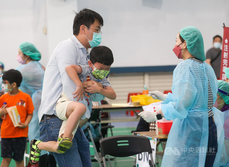 台北市大安區銘傳國小26日開放接種COVID-19兒童疫苗,有孩童害怕打針,需要家長抱著安撫才能順利施打。中央社記者鄭清元攝 111年5月26日
