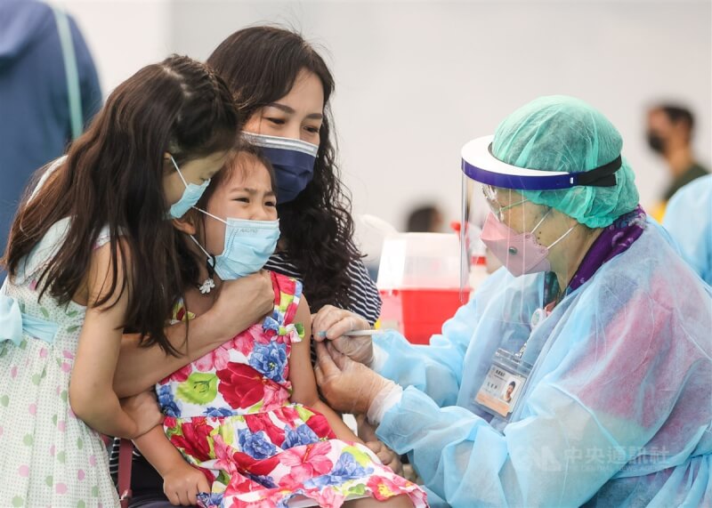 台北市大安區銘傳國小26日開打COVID-19兒童疫苗，有小朋友因為緊張而抗拒打針，家人在旁陪同安撫。中央社記者鄭清元攝 111年5月26日