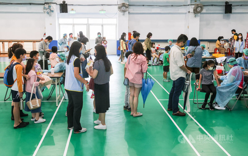 台北市大安區銘傳國小26日上午開放施打兒童疫苗,許多家長帶著孩子前來排隊準備接種。中央社記者鄭清元攝 111年5月26日