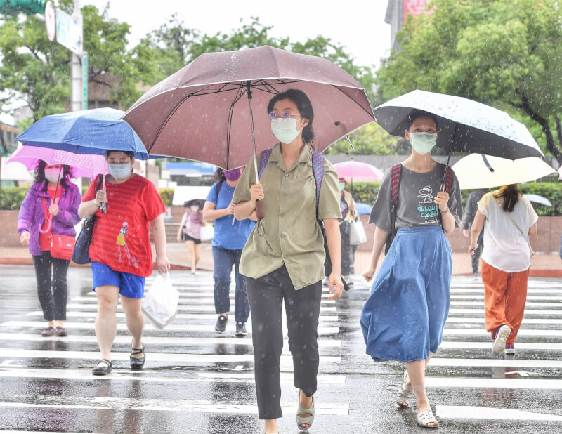 中央氣象局指出，26日鋒面仍在台灣上空，各地整天都有降雨情形。圖為民眾撐傘走在台北車站街頭。（中央社檔案照片）