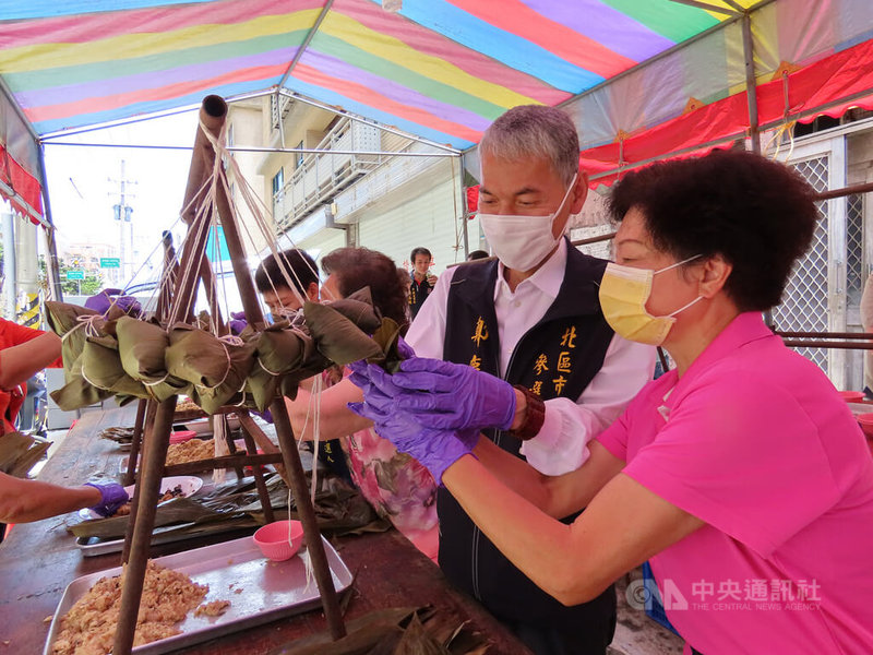 新竹市風廚師餐飲觀光發展協會結合在地企業,29日在新竹市北區、東區舉辦公益活動,提供3000顆肉粽供民眾免費領取,現場由協會成員帶領民眾一起包粽,感受濃濃端午氣氛。中央社記者魯鋼駿攝 111年5月29日