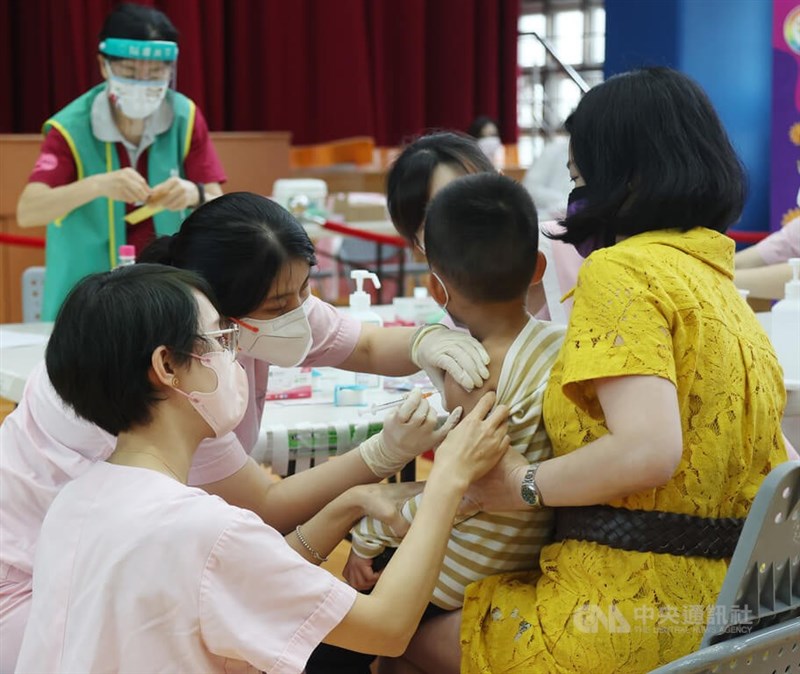 圖為28日北市家長陪幼童赴松山區健康國小接種兒童疫苗。（中央社檔案照片）