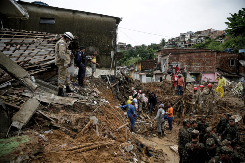 巴西東北部地區日前降下傾盆大雨造成山崩，救難人員在災難現場搜救。（法新社）