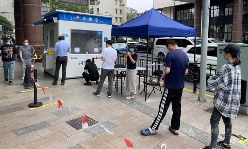 隨著上海解封,72小時核酸檢測結果成日常必需品,1日開始,各地快速檢測站湧現人潮。圖為上海徐匯區的一處採樣站,民眾正在排隊等待「開門」。中央社記者吳柏緯上海攝 111年6月2日