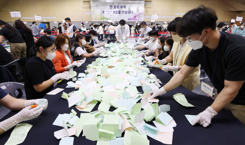 韓國第8屆地方選舉開票結果出爐，執政黨國民力量在全國17個一級行政區中以12比5大勝最大在野黨共同民主黨。圖為韓國世宗市選務人員1日清點票數。（韓聯社）